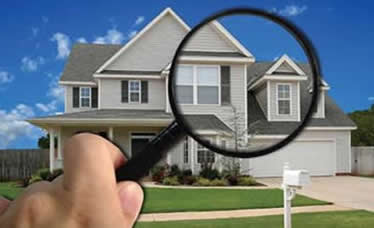 A magnifying glass over a home for sale
